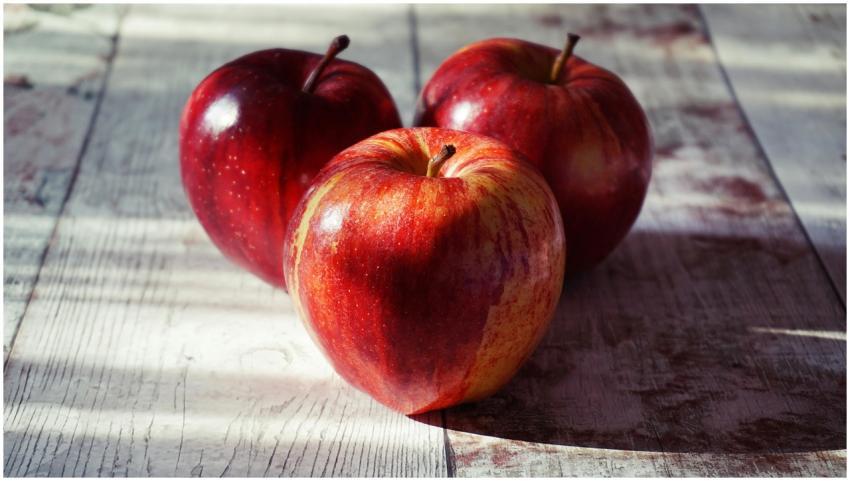 Close-up of fresh red apples on a rustic wooden ta