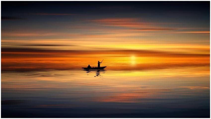 Silhouette of two people in a boat against a vibra