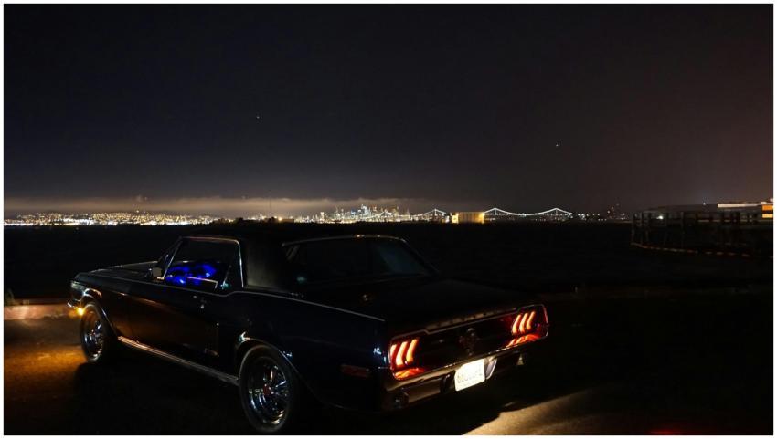 Iconic Mustang parked by the waterfront with city