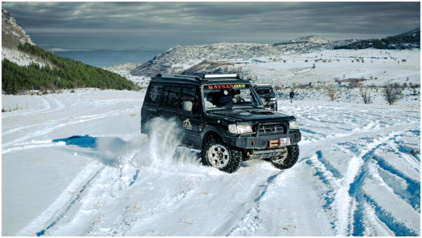 4x4 vehicle navigating snowy terrain in a winter a