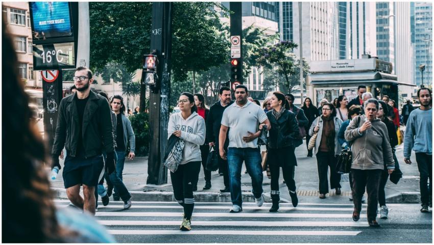 A diverse group of people crossing a street in a b