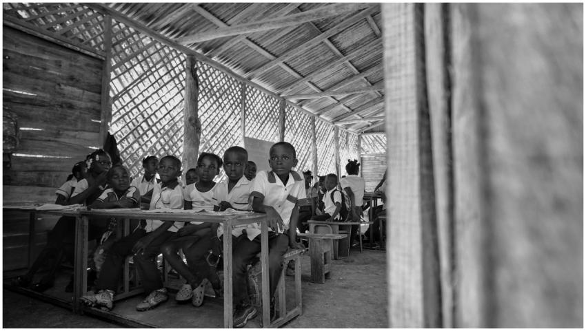 Children in a rustic classroom in Haiti engage in