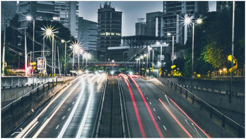 Dynamic night view of urban expressway with skyscr