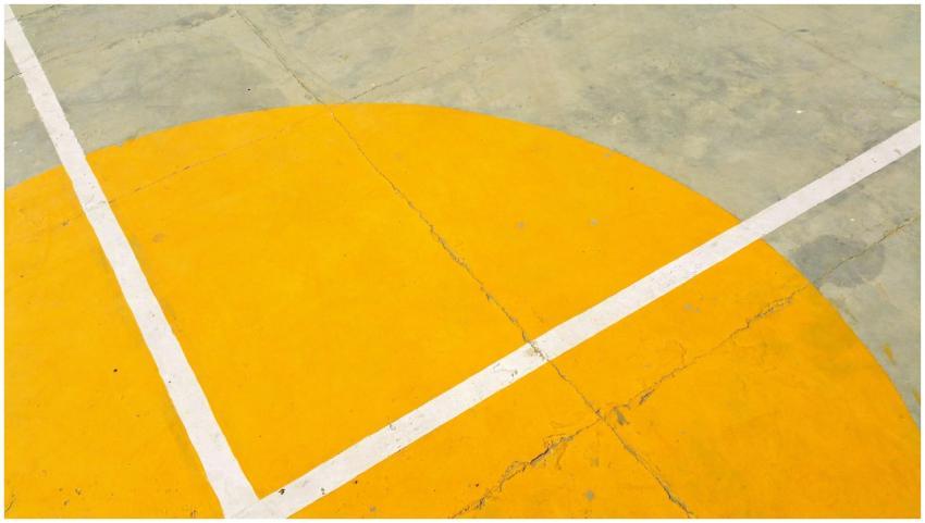 Close-up of a basketball court with yellow semicir