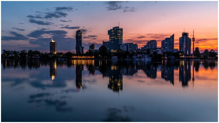 Tranquil reflection of Vienna's cityscape at sunse