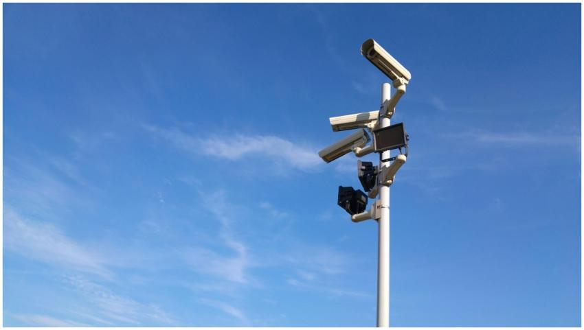 Multiple security cameras on a pole with a clear b