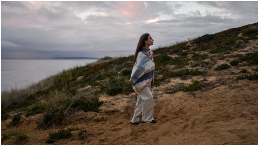 A serene moment as a woman wrapped in a blanket ga