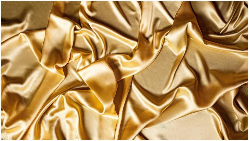 Close-up of golden silk fabric showcasing smooth a