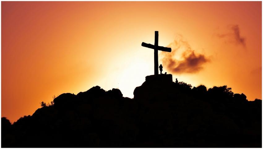 Majestic silhouette of a cross on a hill during a