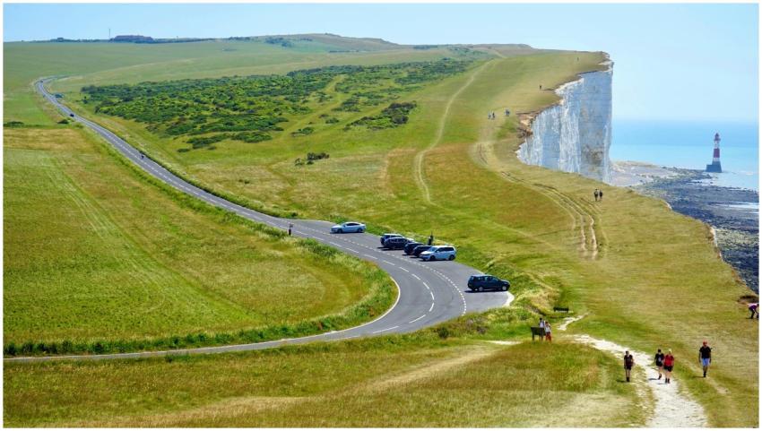 A picturesque coastal road with a lighthouse on cl