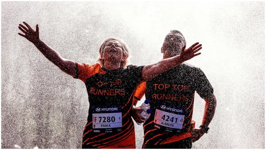 Two runners celebrating with arms outstretched und