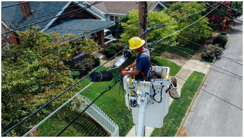 Electrician in a bucket lift repairing power lines