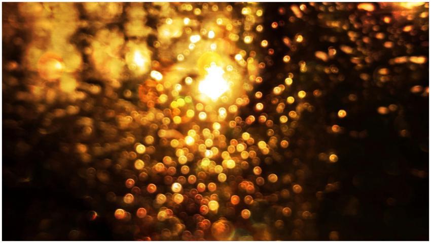 Abstract bokeh image with warm gold tones and rain
