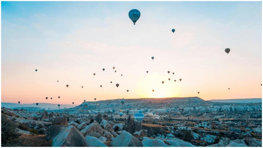 Hot air balloons soar over Cappadocia at sunrise,