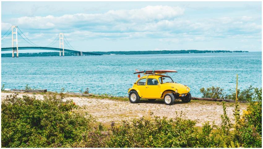 Scenic view of a yellow beetle with surfboard near