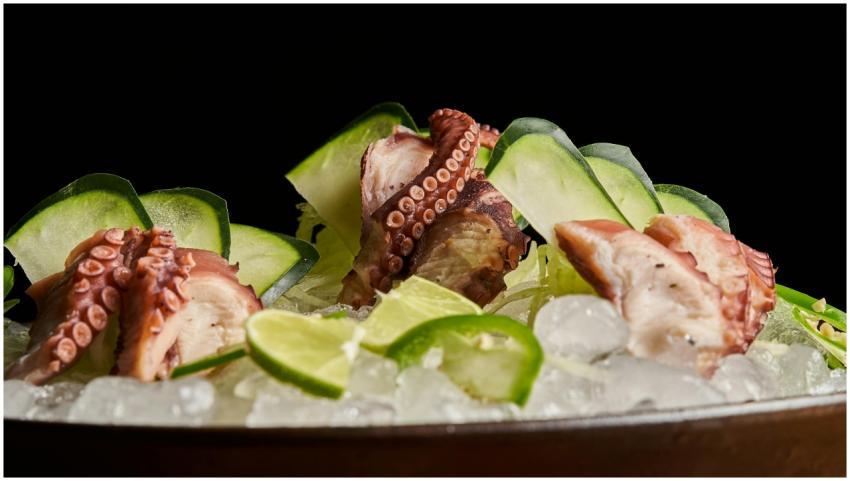 Sliced octopus tentacles garnished with lime and c