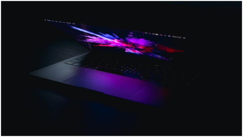 A laptop displaying a vibrant abstract design in l