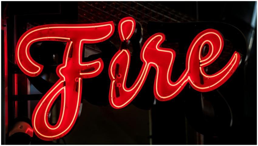 A striking red neon sign spelling 'Fire' in a dark