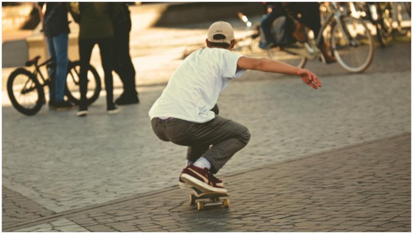 Young man skateboarding outdoors, showcasing actio