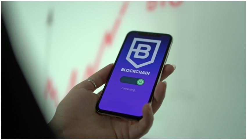 Hand holding smartphone displaying blockchain cryp