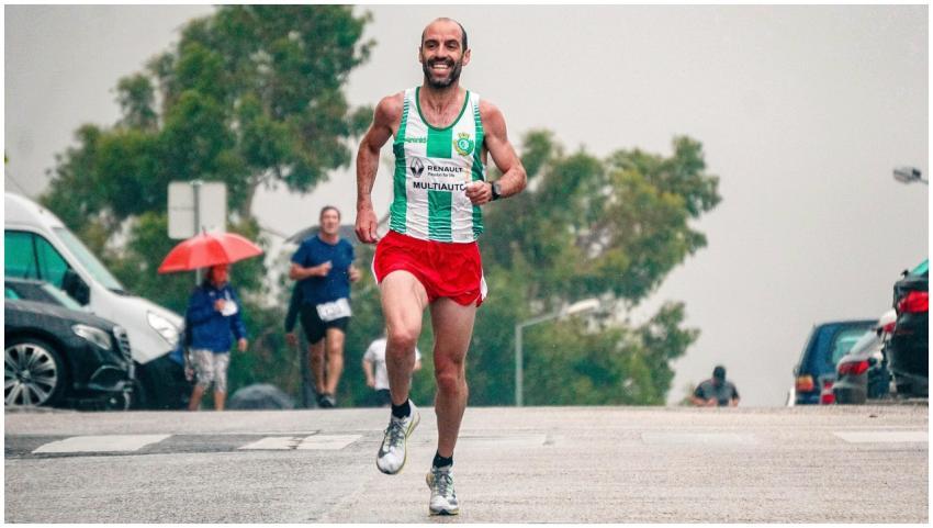 Smiling athlete running in a street marathon durin