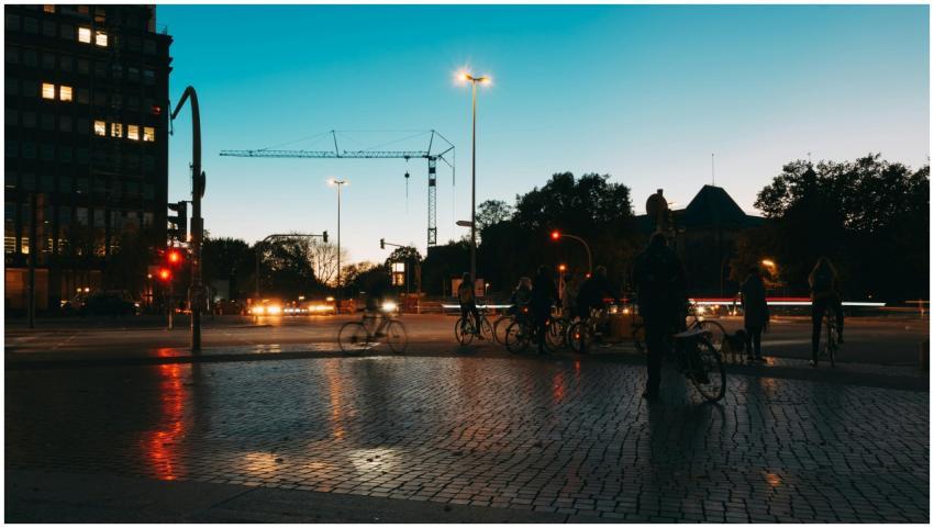 Nighttime street scene with bicyclists, lights, an