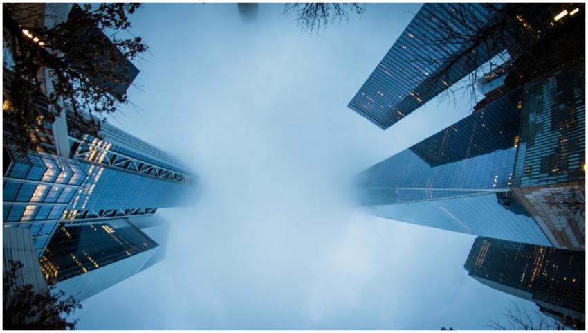 Dramatic view of misty skyscrapers disappearing in