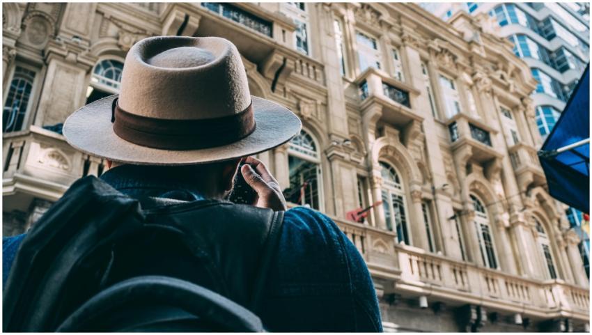 Man photographing ornate historic building with in