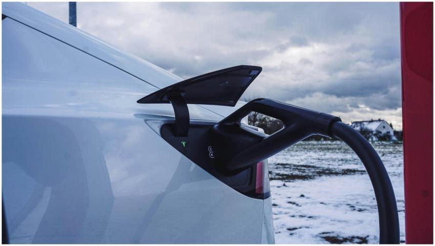 Close-up of a white electric car charging outdoors
