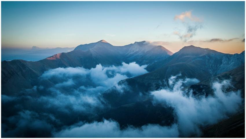 Serene mountain landscape with clouds enveloping p