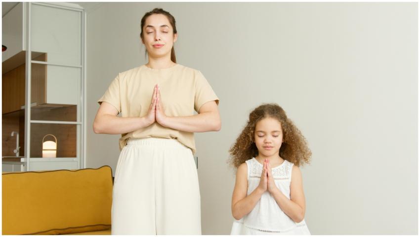 A mother and daughter practicing meditation and pr