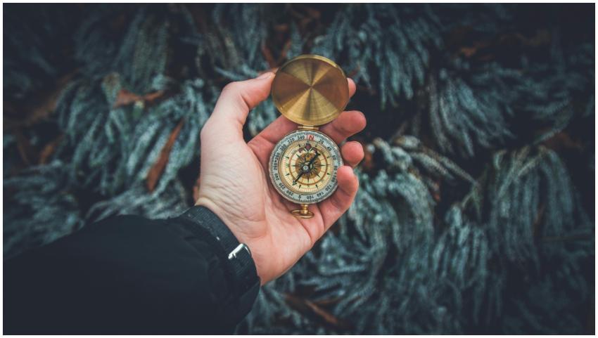A close-up shot of a hand holding a vintage compas