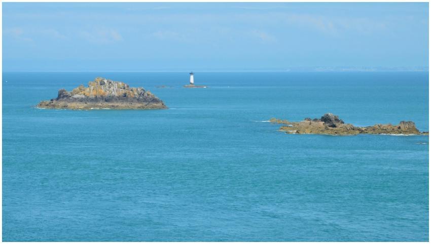 Serene view of rocky islands and lighthouse agains