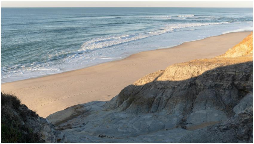 Peaceful beach scene with crashing waves at Nazaré