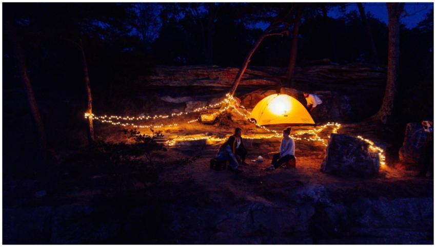 A cozy campsite illuminated by string lights and a