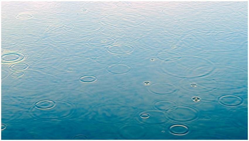 Close-up of raindrops creating ripples on a calm w