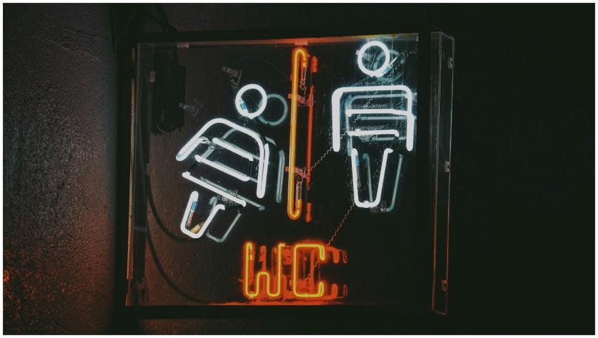 Close-up of neon restroom sign featuring male and