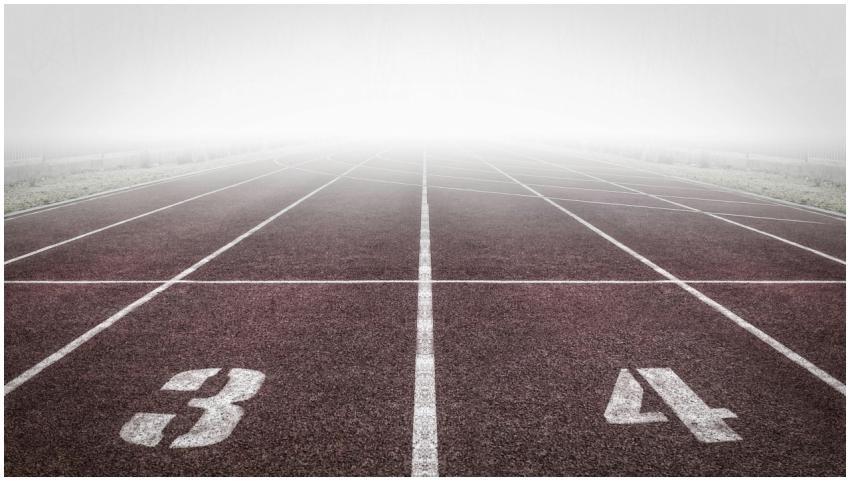 A foggy track field with visible lane numbers and