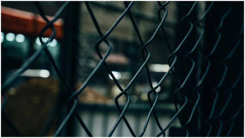 Close-up of a chain link fence with bokeh lights i