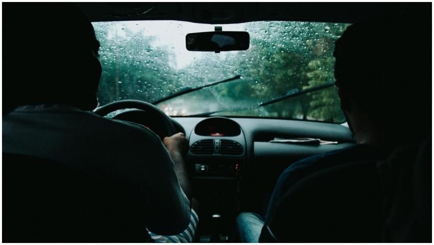 Two people drive through rainy São Paulo streets,