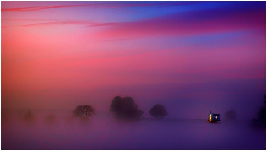 A serene chapel illuminated within a vibrant foggy