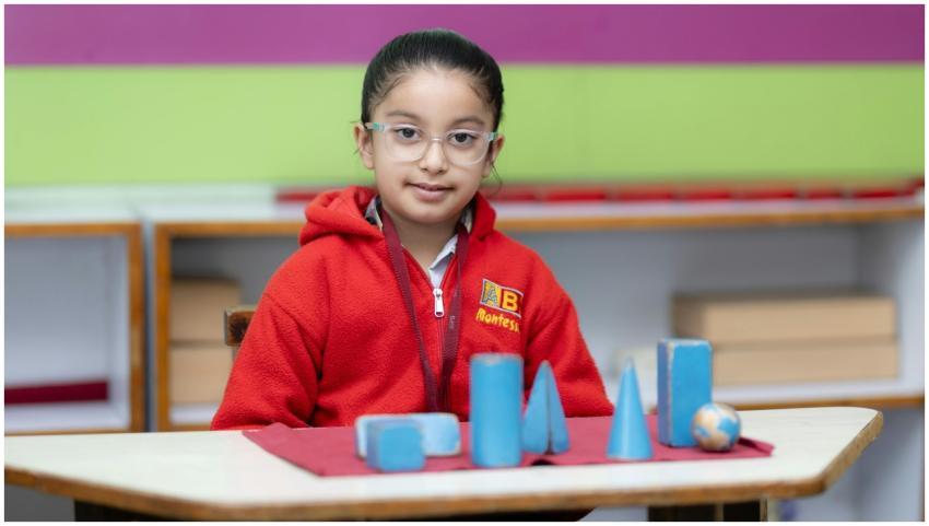 Young girl in red sweater explores geometric shape