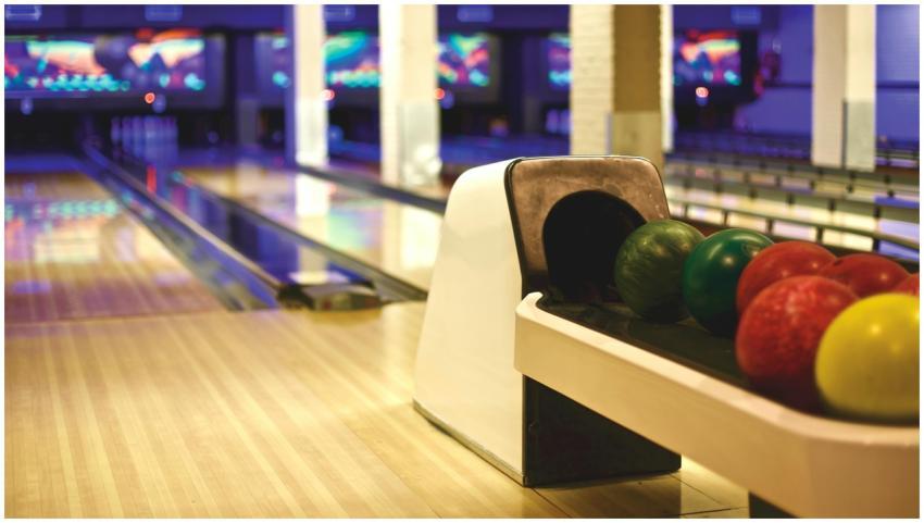 Colorful bowling balls lined up in a modern alley,