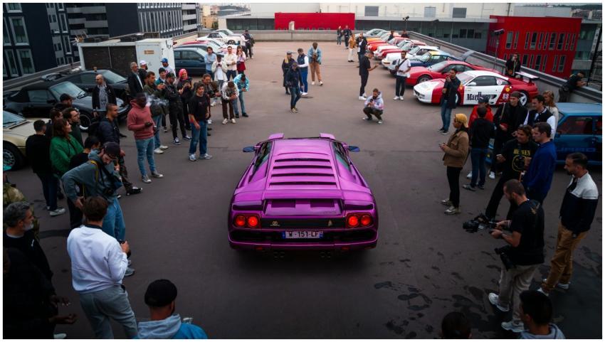 Enthusiasts gather around a vibrant purple sports