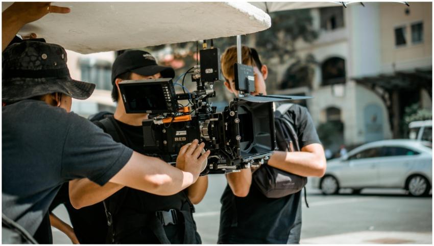 A film crew operates a RED camera on a city street