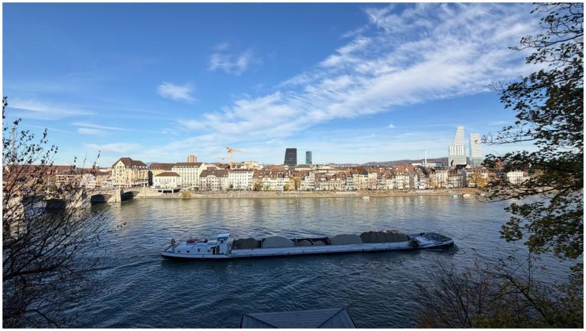 A stunning view of Basel with a boat cruising on t