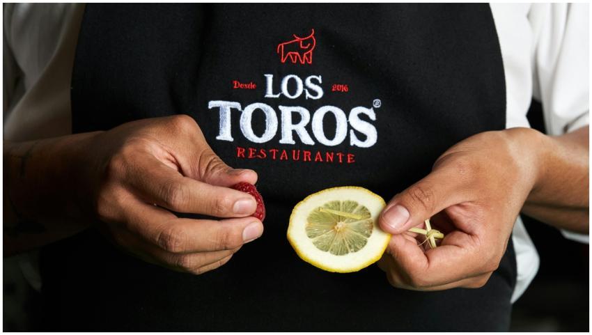 Close-up of chef holding lemon and garnish at Los