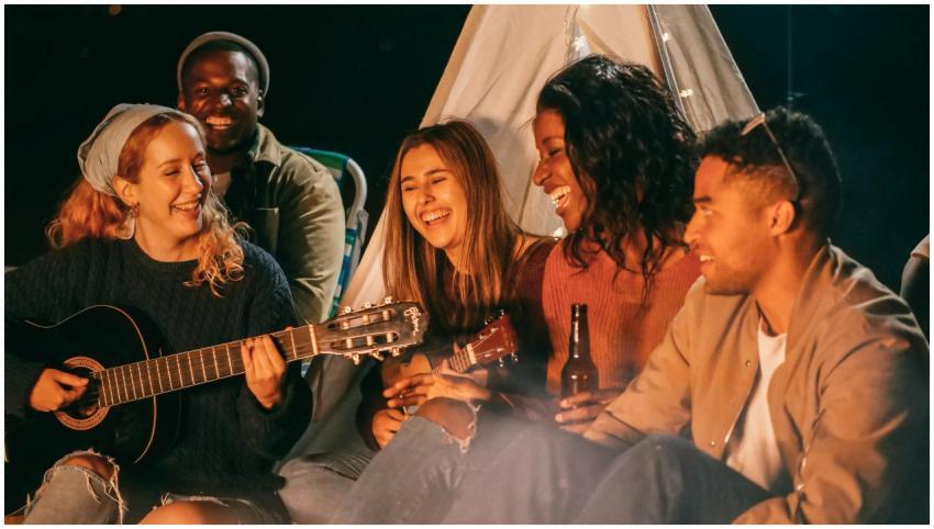 A diverse group of friends playing guitar and ukul