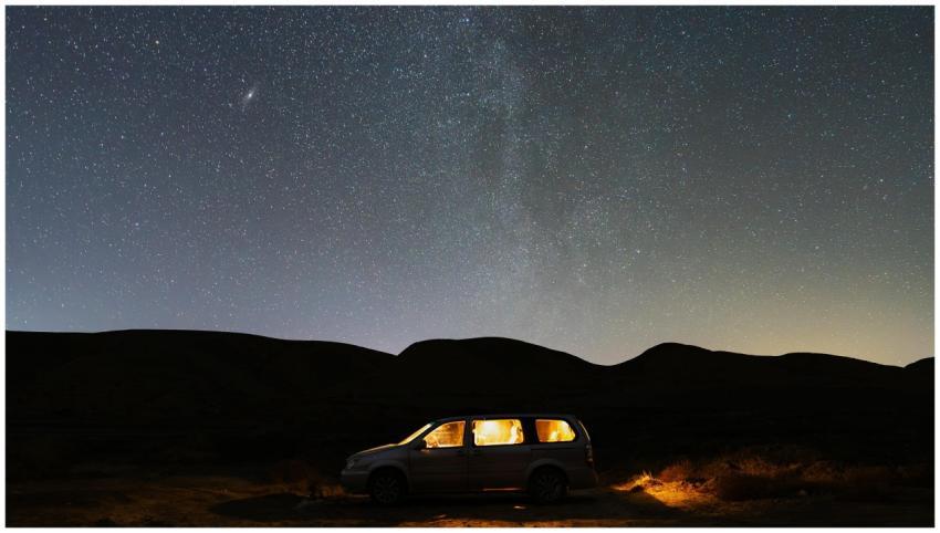 A peaceful desert scene with a glowing car under a