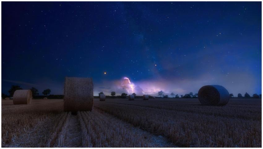 A scenic rural landscape featuring hay bales under
